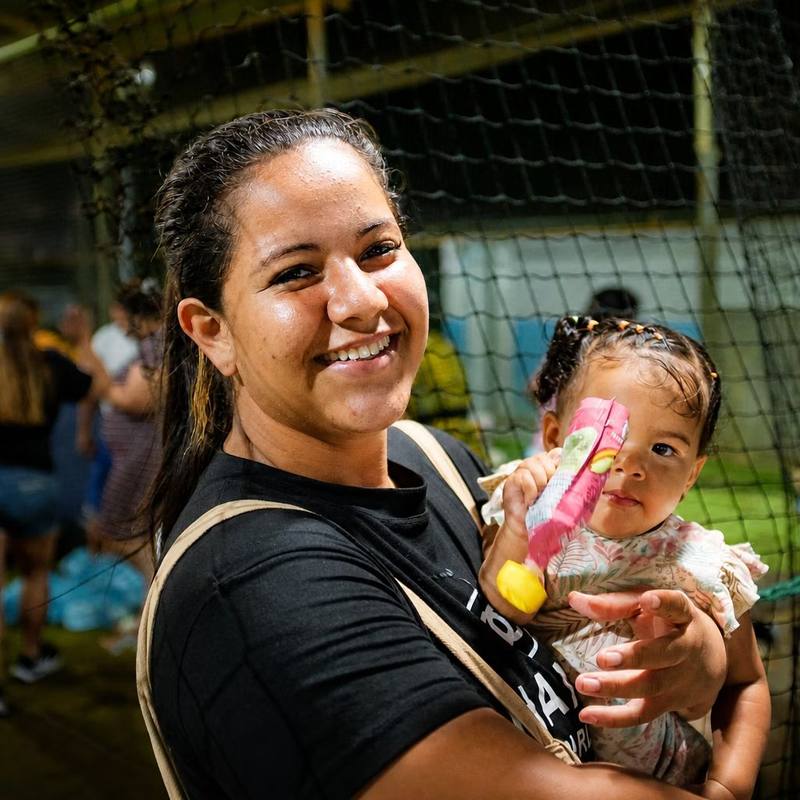 Madre sonriente con su hija en un campamento de familias damnificadas