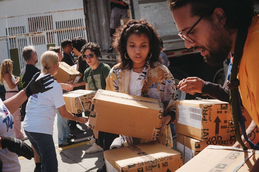 Voluntarios descargan cajas con ayuda humanitaria en Caracas