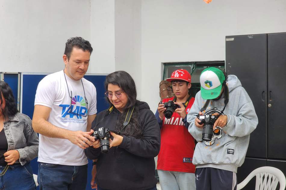 Jóvenes aprenden fotografía con cámaras en un taller de industrias creativas