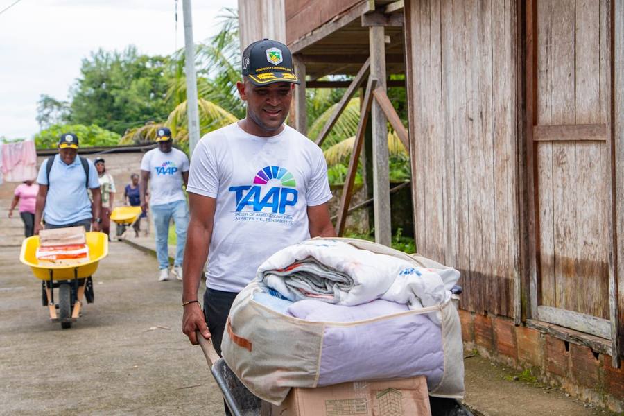 Integrante del equipo de TAAP transporta donaciones por una calle del Chocó
