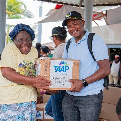 Líder comunitaria recibe una caja con ayuda de Fundación TAAP