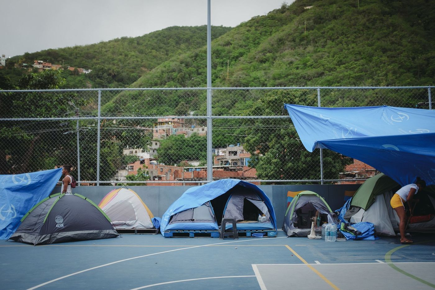Carpas de familias damnificadas en un refugio temporal instalado en una cancha deportiva en Venezuela